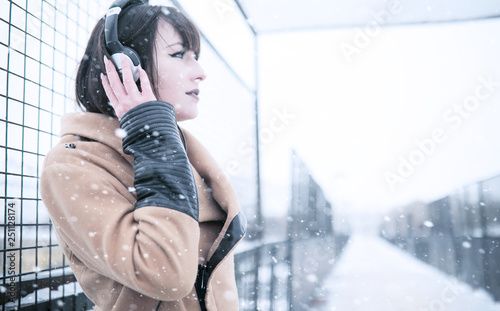 Girl in headphones listening to music outdoors