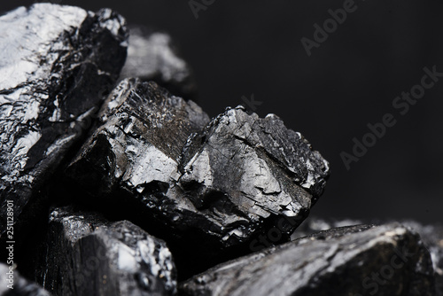 Natural coal on a black background isolated closeup. Extraction of natural mineral resources. photo