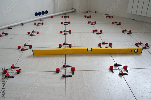 Fotografi Checking of the evenness of laying tiles with profile level