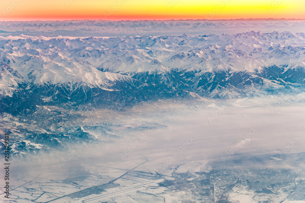 aerial view to  russian agriculture landscape in snow with himalayan mountains