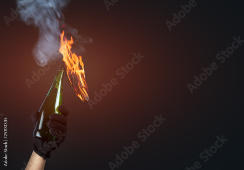 Molotov cocktail in activist hand on dark background © Ivan Kmit
