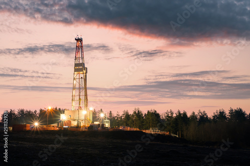 Oil gas drilling rig on sunset background. Industrial concept