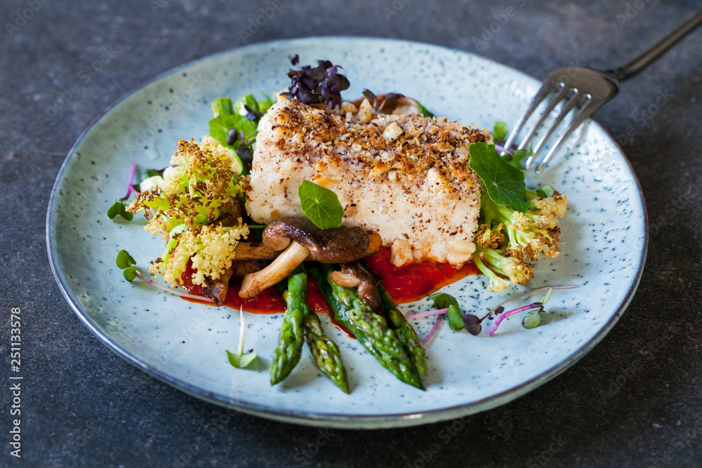Halibut with hazelnut crust with roast red pepper sauce, asparagus, cauliflower and shiitake mushrooms
