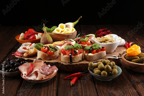Italian antipasti wine snacks set. Cheese variety, Mediterranean olives, pickles, Prosciutto di Parma, tomatoes, artichokes