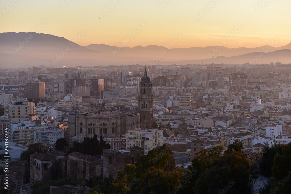 Cityscape aerial view of the center of Malaga, the Cathedral and mountains during a beautiful sunset with cloudy sky, Malaga, Spain