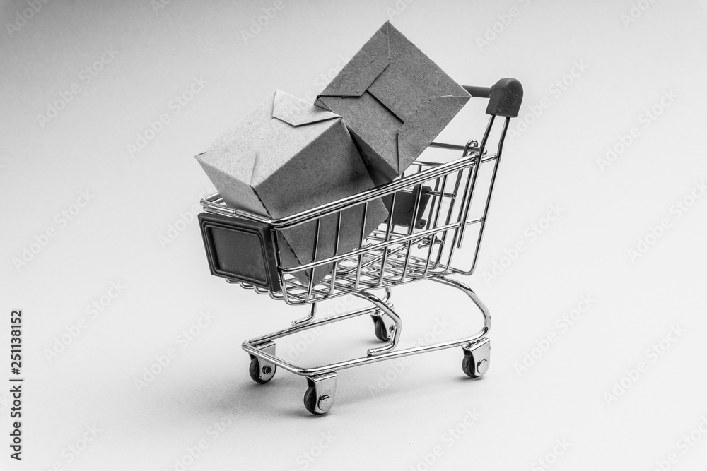 Shopping cart and box on black and white background, business and shopping concept. Selective focus Shopping cart and box on black and white background, business and shopping concept. Selective focus