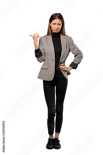 A full-length shot of a Business woman unhappy and pointing to the side over isolated white background