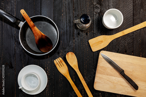 Set of kitchenware on the black wooden background