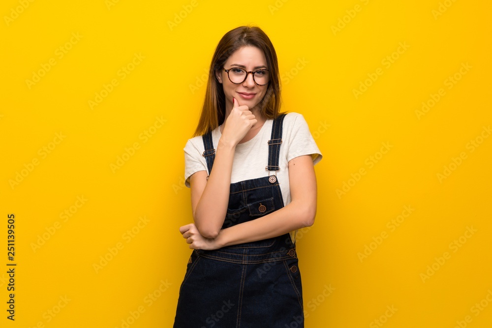Woman over yellow wall thinking Woman over yellow wall thinking