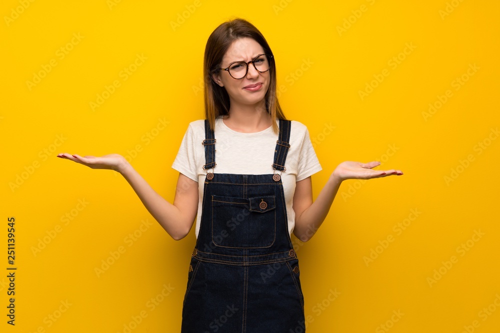 Woman over yellow wall unhappy because not understand something Woman over yellow wall unhappy because not understand something