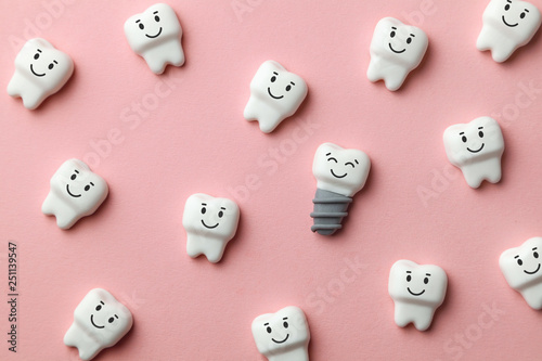 Healthy white teeth and implants are smiling on pink background