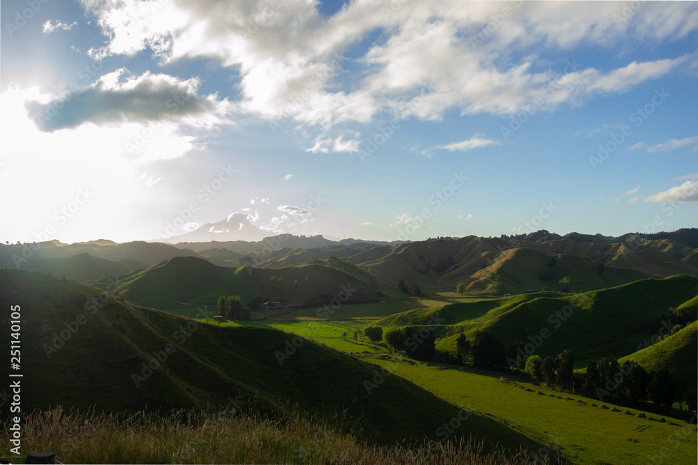 A typic new zealand landscape with green mountains during the sunset