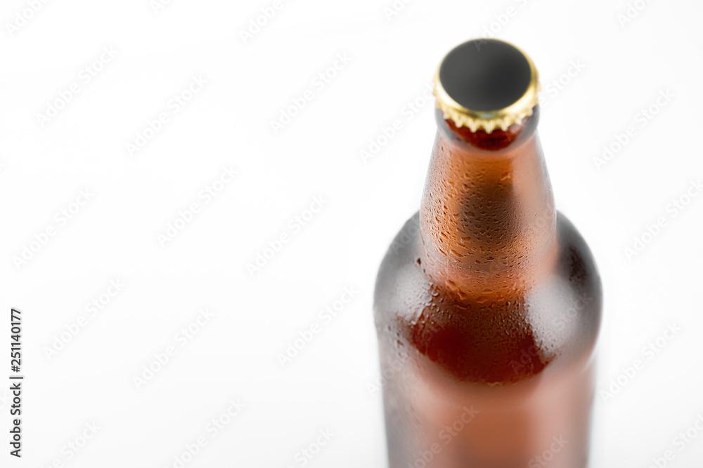Studio photo of isolated bottle of beer on white background. Cold bottle of beer with condensate water drops on it. Beer bottle with water drops isolated on white