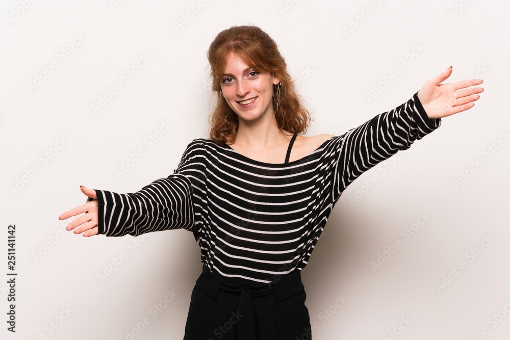 Young redhead woman over white wall presenting and inviting to come with hand Young redhead woman over white wall presenting and inviting to come with hand