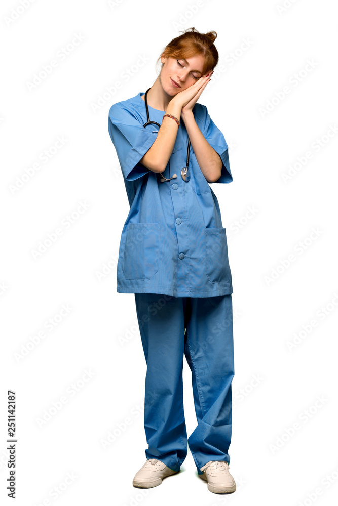 A full-length shot of a Young redhead nurse making sleep gesture in dorable expression over isolated white background A full-length shot of a Young redhead nurse making sleep gesture in dorable expression over isolated white background