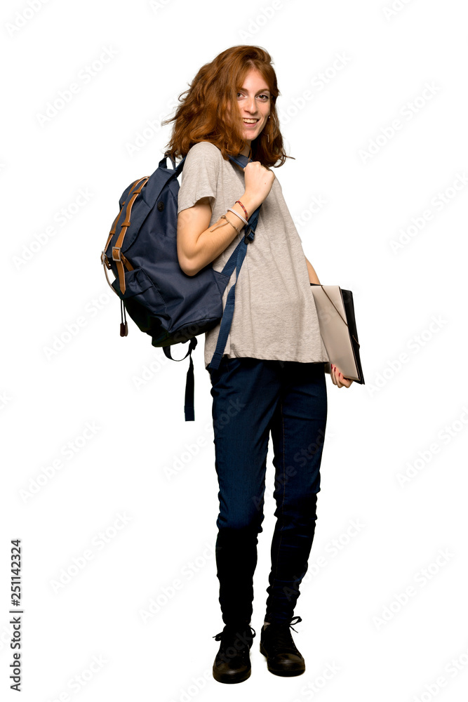 A full-length shot of a Young redhead student posing with arms at hip and laughing over isolated white background A full-length shot of a Young redhead student posing with arms at hip and laughing over isolated white background
