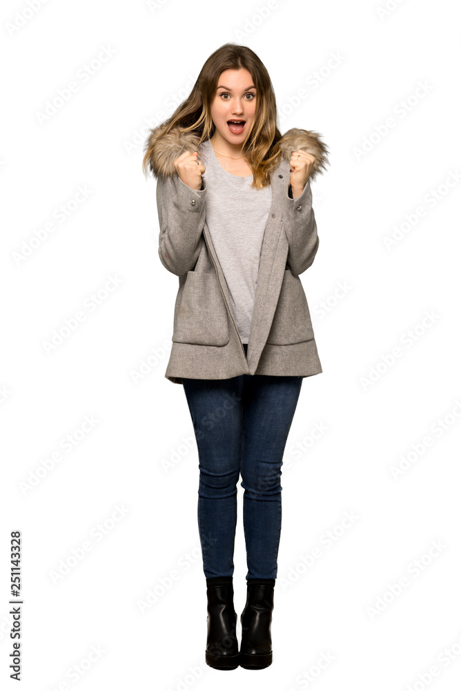 A full-length shot of a Teenager girl with coat celebrating a victory in winner position on isolated white background A full-length shot of a Teenager girl with coat celebrating a victory in winner position on isolated white background