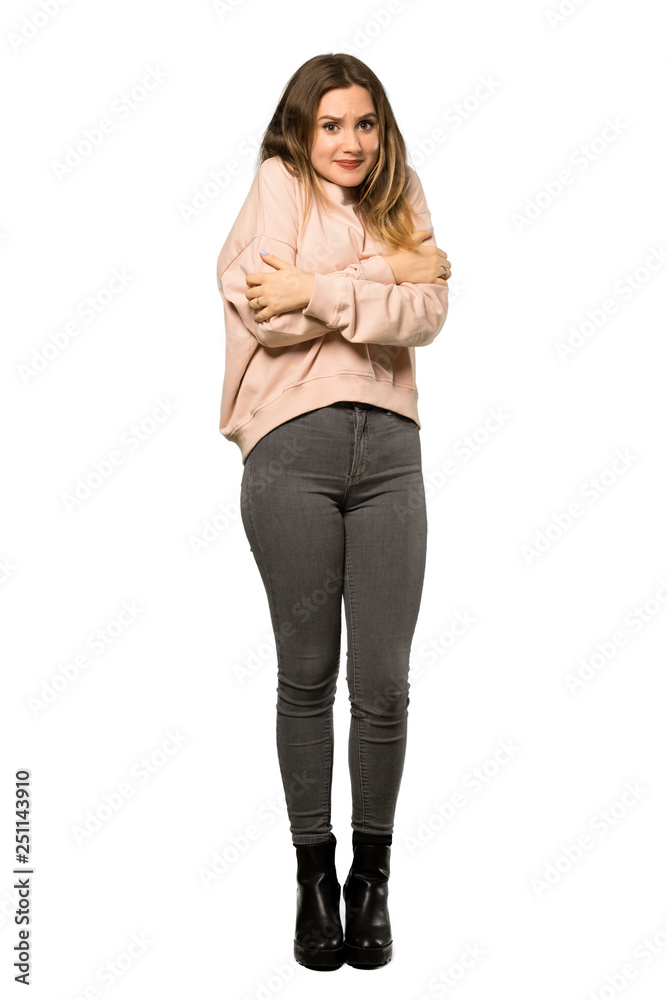 Fototapeta premium A full-length shot of a Teenager girl with pink sweater freezing over isolated white background