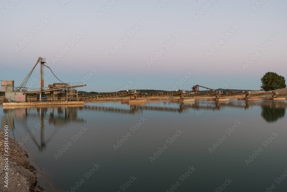 flooded gravel pit and mining in the evening