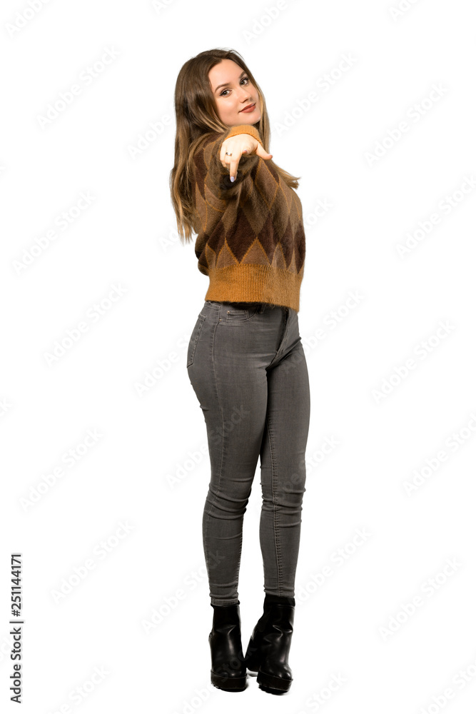 A full-length shot of a Teenager girl with brown sweater points finger at you with a confident expression over isolated white background A full-length shot of a Teenager girl with brown sweater points finger at you with a confident expression over isolated white background