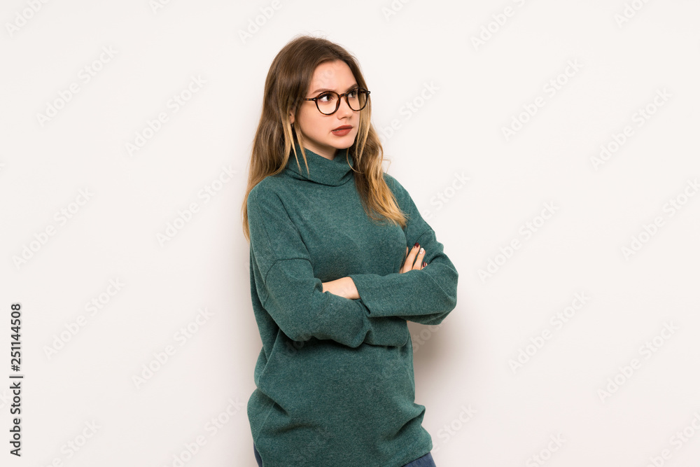 Teenager girl over white wall with confuse face expression while bites lip Teenager girl over white wall with confuse face expression while bites lip