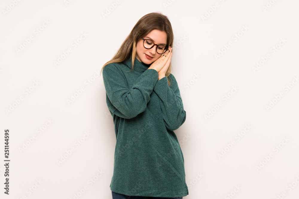 Teenager girl over white wall making sleep gesture in dorable expression Teenager girl over white wall making sleep gesture in dorable expression