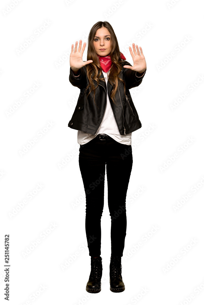 Full-length shot of Young woman with leather jacket making stop gesture for disappointed with an opinion on isolated white background Full-length shot of Young woman with leather jacket making stop gesture for disappointed with an opinion on isolated white background