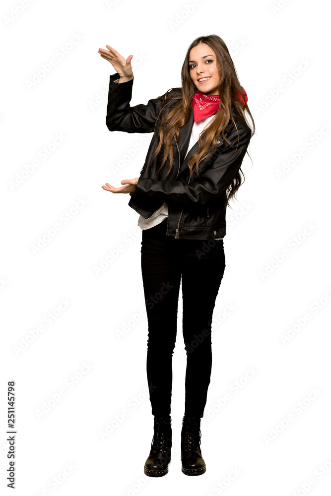 Full-length shot of Young woman with leather jacket holding copyspace to insert an ad on isolated white background Full-length shot of Young woman with leather jacket holding copyspace to insert an ad on isolated white background