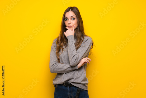 Young woman over yellow wall smiling and looking to the front with confident face