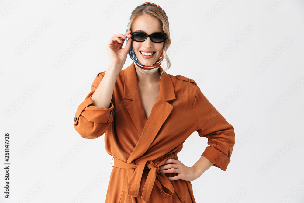 Beautiful young woman wearing silk stylish scarf posing isolated over white wall background wearing sunglasses. Beautiful young woman wearing silk stylish scarf posing isolated over white wall background wearing sunglasses.