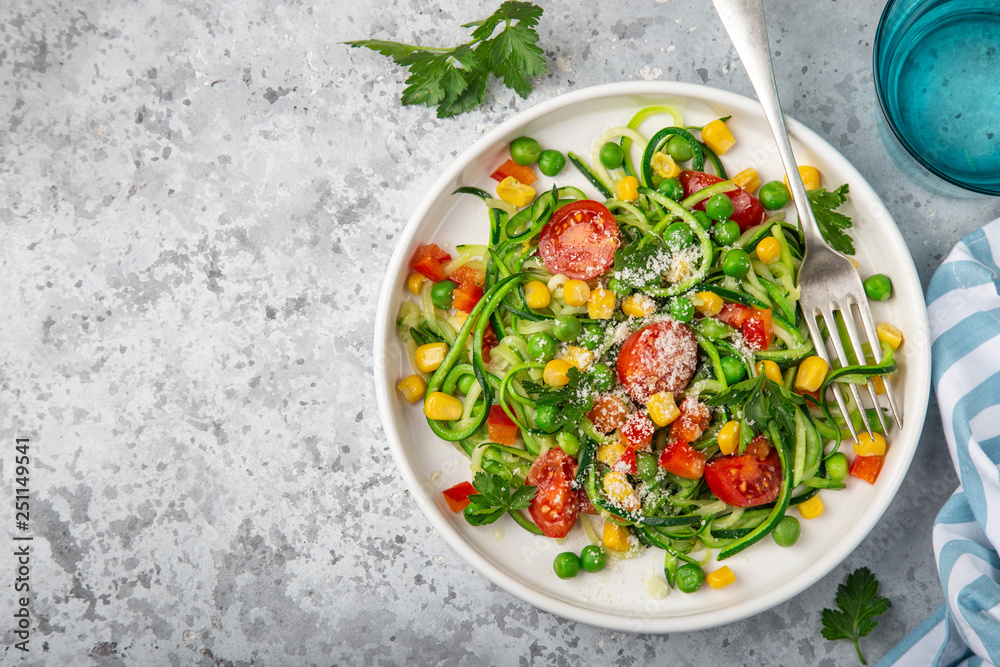 zoodle (zucchini noodle) with vegetables on white plate zoodle (zucchini noodle) with vegetables on white plate