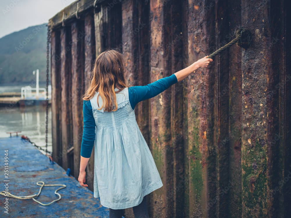 Obraz premium Young woman holding a rope in a shipyard