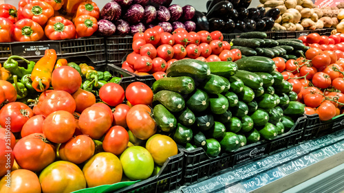 Cucumbers  onions  tomatoes and other vegetables are on the counter of the supermarket