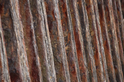 A close up photograph of a rusty old metal sea barrier wall.  Abstract old worn background texture