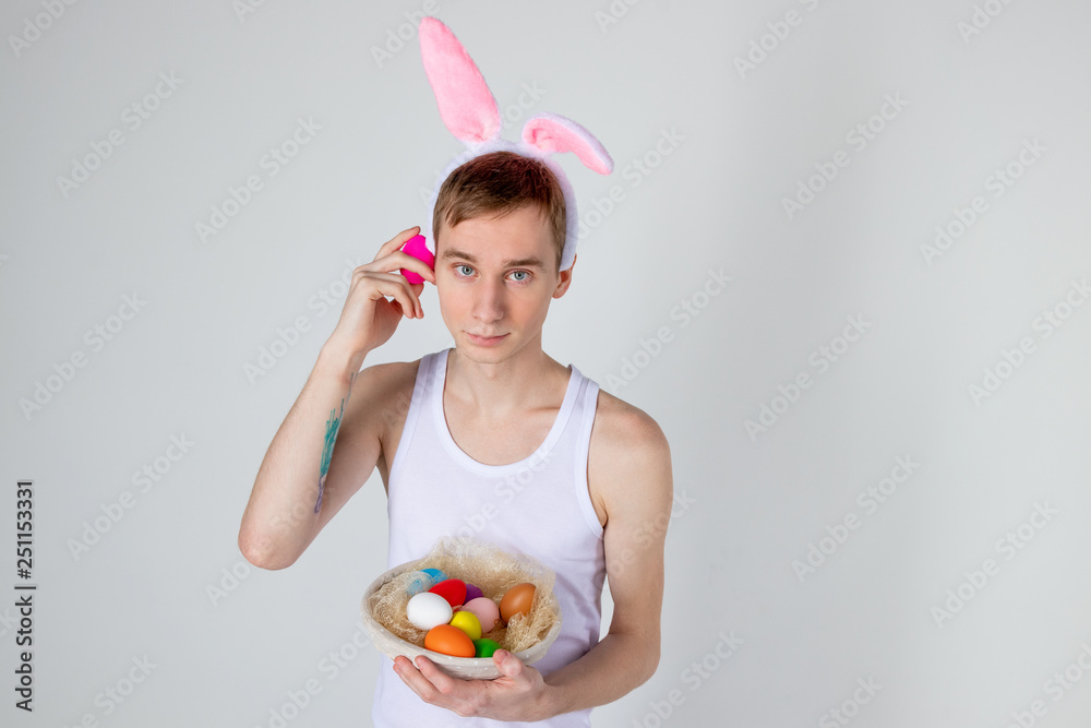 Handsome guy with bunny ears holding basket with eggs. Happy Easter concept