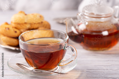 transparent teapot and cup of hot tea