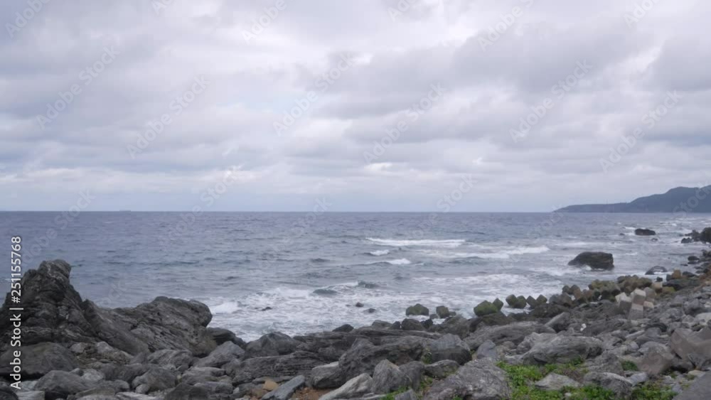 Rocky cliff beach with strong wave and wind in cloudy day- Rocky cliff beach in Okinawa,Japan Rocky cliff beach with strong wave and wind in cloudy day- Rocky cliff beach in Okinawa,Japan