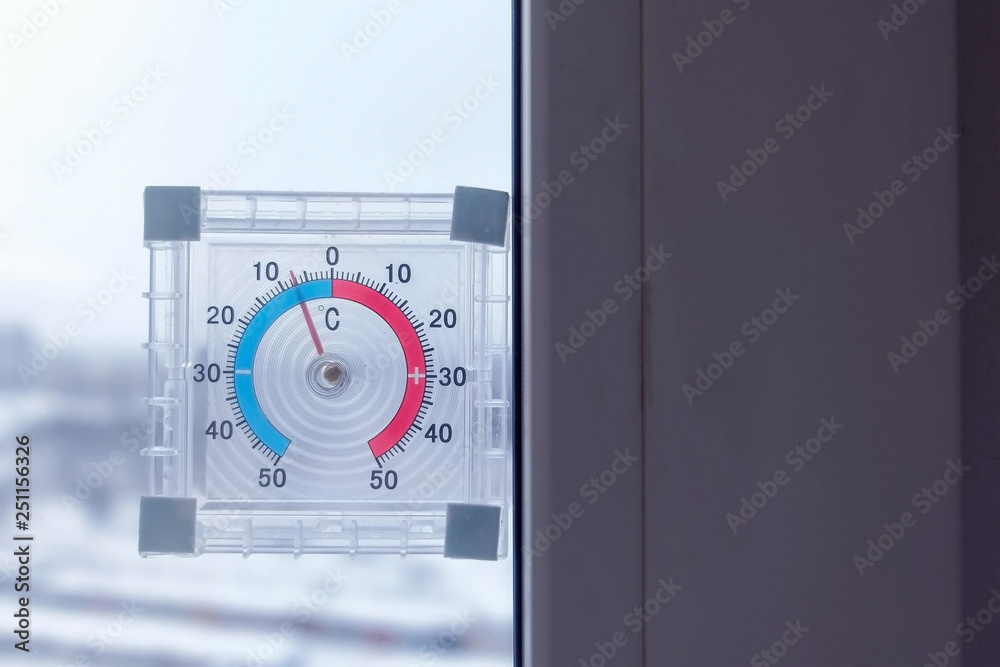 Naklejka premium Thermometer on the window with negative temperature in winter.
