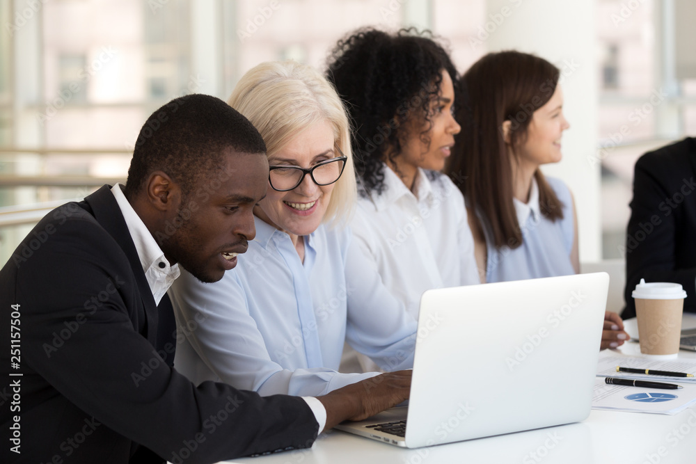 Businesspeople sitting at desk focus on aged female black male Businesspeople sitting at desk focus on aged female black male