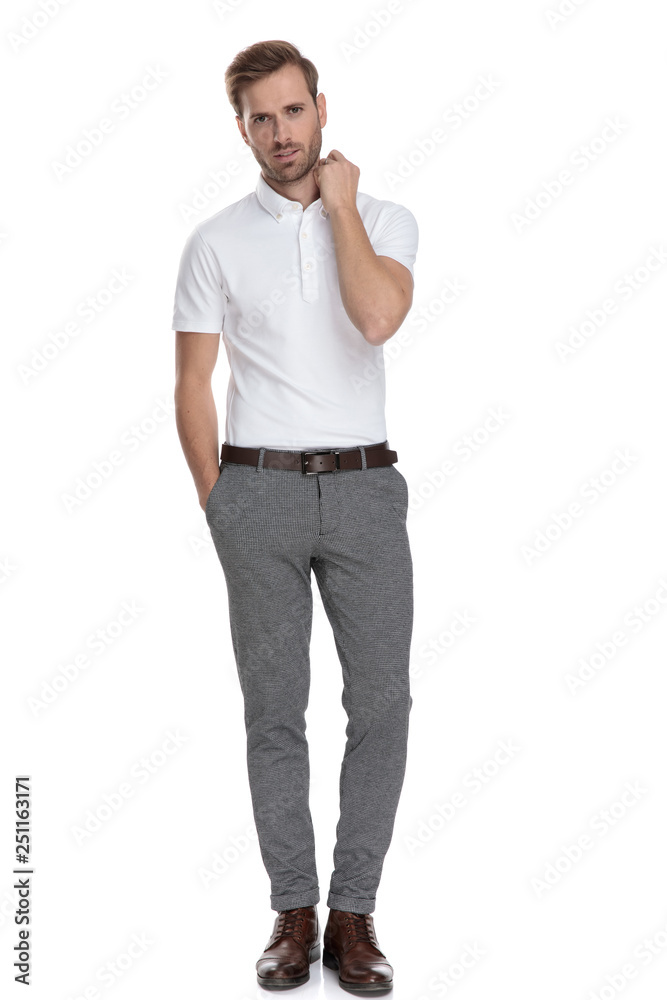 Fototapeta premium full body picture of a young man fixing his collar