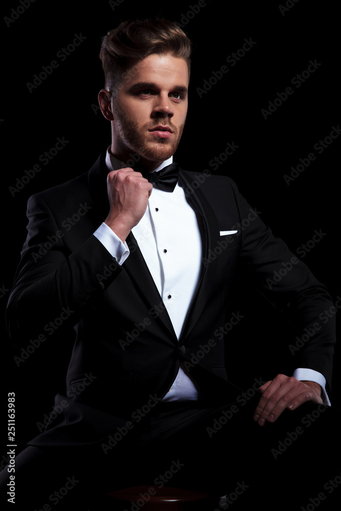 young elegant man fixing his bowtie young elegant man fixing his bowtie