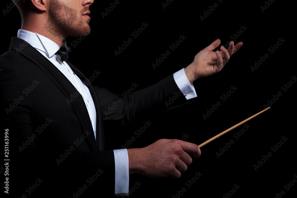 young musician conducting using a stick and gesturing young musician conducting using a stick and gesturing