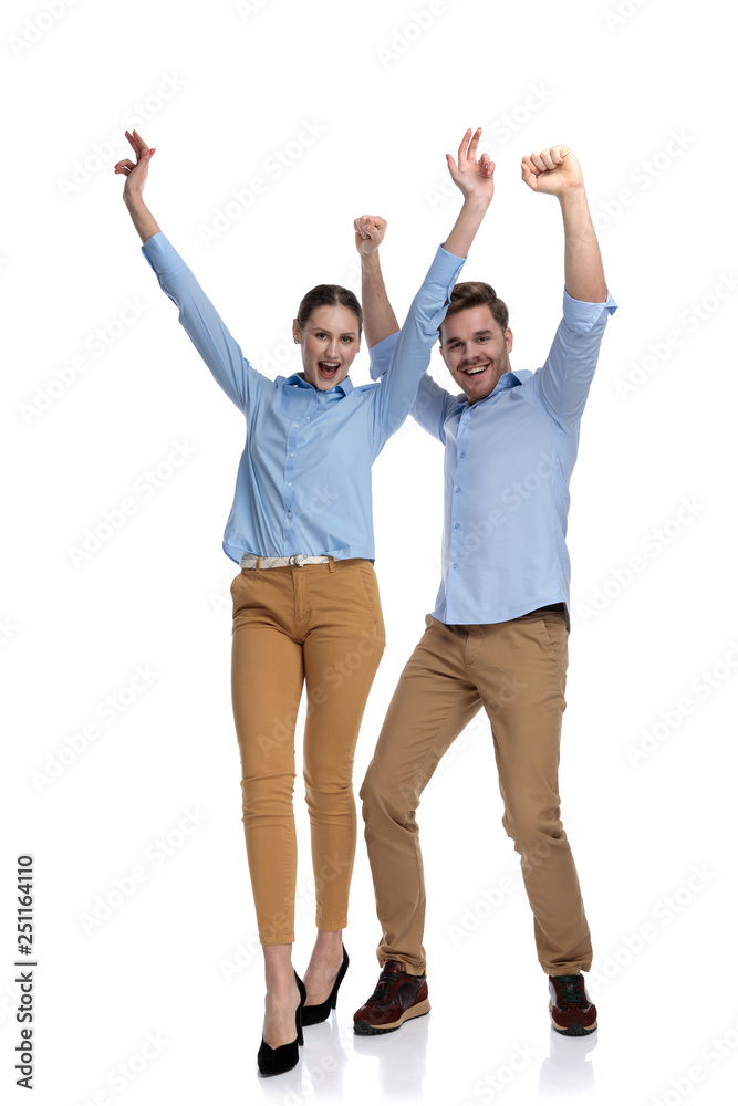 young casual couple with hands in the air screams young casual couple with hands in the air screams