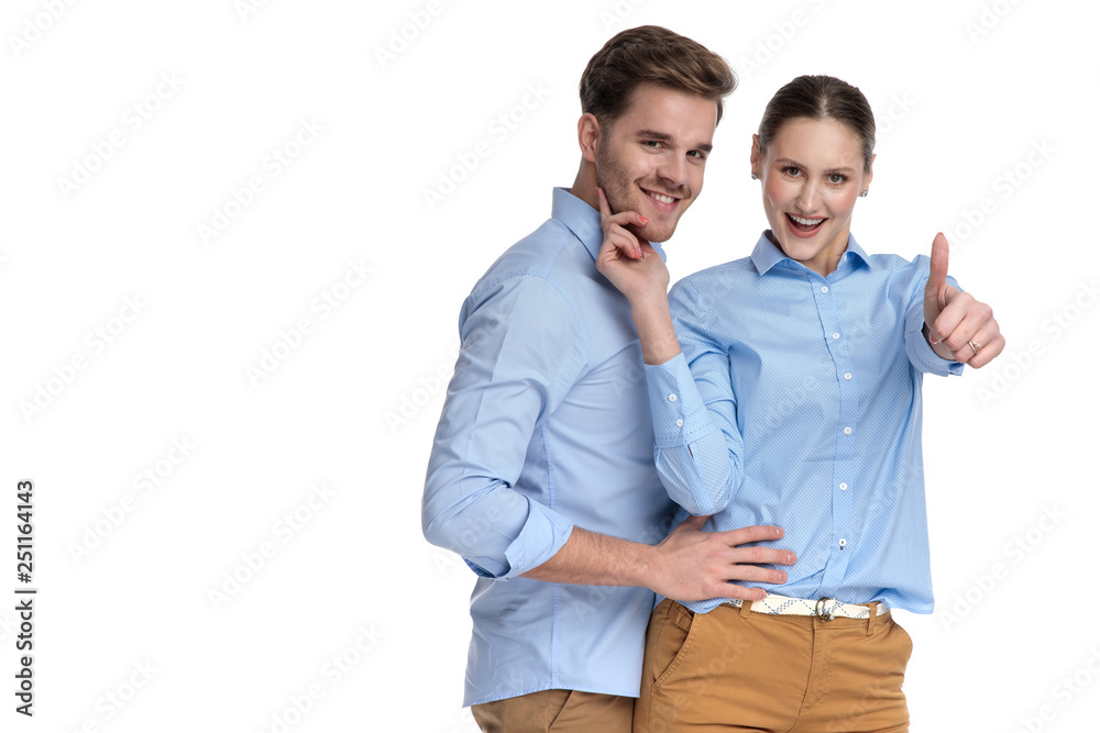 embraced happy casual couple, woman makes the ok sign embraced happy casual couple, woman makes the ok sign