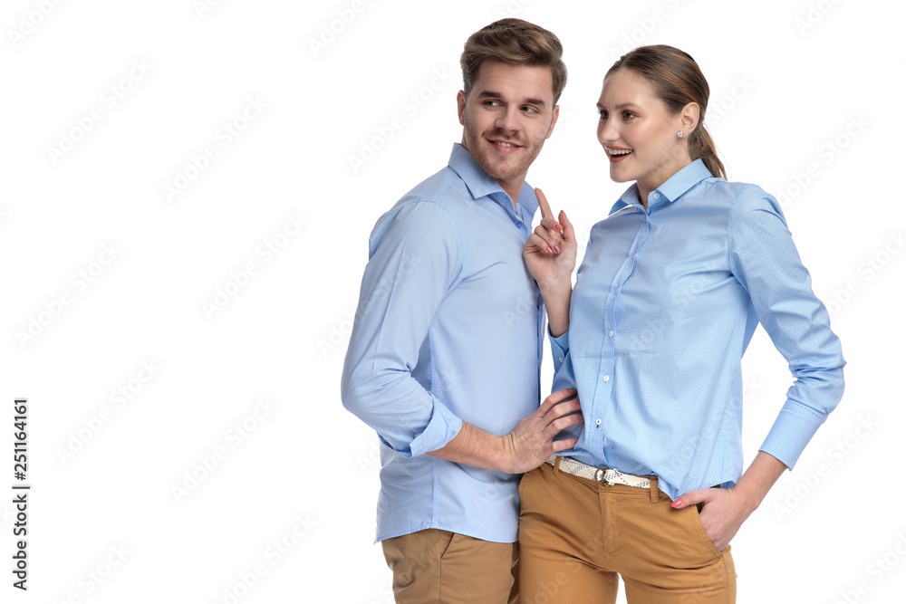 woman pointing to side while man holds her by waist woman pointing to side while man holds her by waist