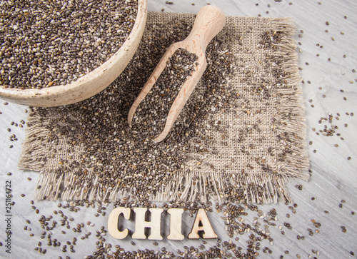 Fényképezés Chia seeds on wooden background. A component of a healthy diet.