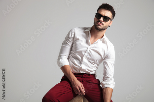 attractive man gives a serious look while leaning on the side © Viorel Sima
