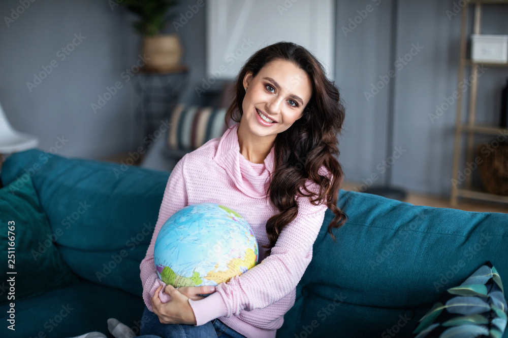 Smiling woman with globe at home. Smiling woman with globe at home.