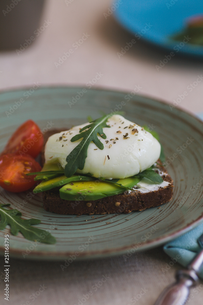 sandwich with avocado, poached egg, arugula and cherry tomatoes sandwich with avocado, poached egg, arugula and cherry tomatoes