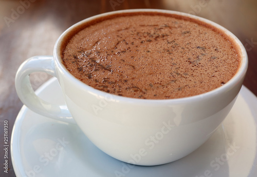 Closed up a cup of hot chocolate served on wooden table